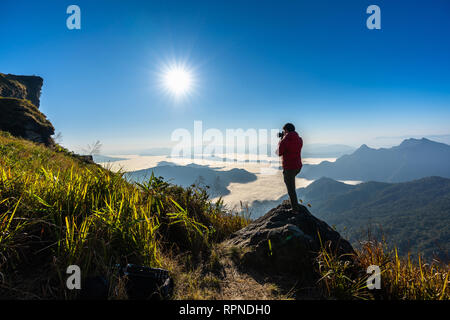 Appareil photo et photographe main tenant debout sur le rocher dans la nature. Concept de voyage. Banque D'Images