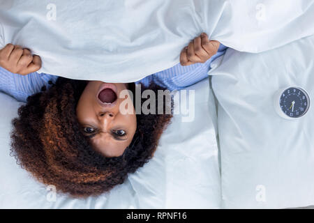 Peur woman Lying in Bed. haut voir photo.angry girl déteste ses voisins bruyants Banque D'Images