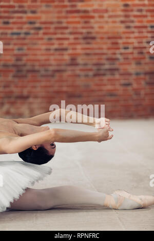 Gracefullness concept. close up portrait photo, la gymnaste est de faire quelques exercices sur le plancher dans la chambre loft Banque D'Images