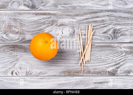 Orange fruit orange et bâtonnets de bois pour les pousseurs cuticule manucure. Copyspace pour votre texte, bannière. Banque D'Images