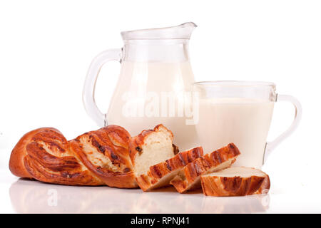 Verseuse et verre de lait avec une miche de pain isolé sur fond blanc Banque D'Images