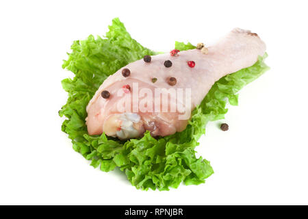 Pilons de poulet cru avec une feuille de laitue et le poivre isolé sur fond blanc Banque D'Images