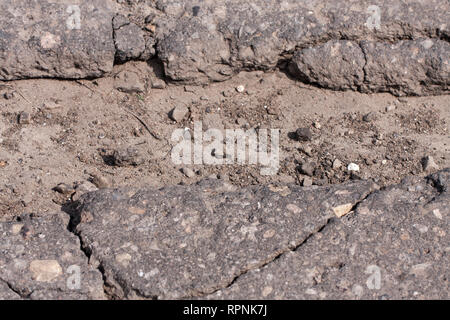 Grande fosse avec des pierres sur la route d'asphalte Banque D'Images