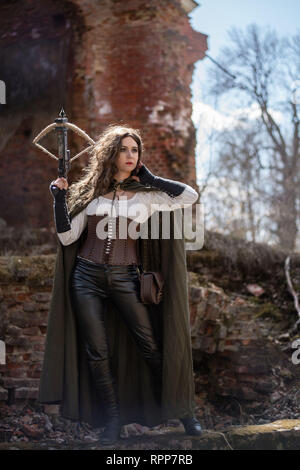 Girl hunter avec une arbalète sur les ruines d'un château Banque D'Images