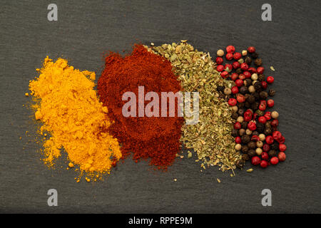 La texture de fond de fines herbes Épices du curcuma, piment doux, basilic, poivre noir, poivre rouge et de poivre blanc. Épices colorés pour la viande Banque D'Images