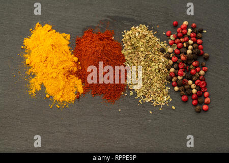 La texture de fond de fines herbes Épices du curcuma, piment doux, basilic, poivre noir, poivre rouge et de poivre blanc. Épices colorés pour la viande Banque D'Images