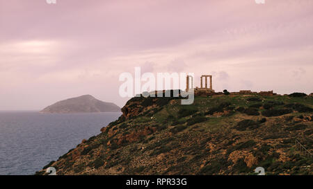 Coucher du soleil à d'anciennes ruines du temple de Poséidon sous ciel avec nuages à l'heure d'hiver à Sounio, Grèce Banque D'Images