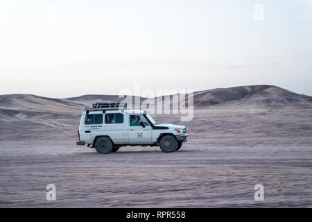 Hurghada, Egypte - Février 26, 2017 : voiture, jeep ou 4x4 hors route pendant la conduite dans le désert blanc sur fond de ciel. Safari tour. L'activité extrême. Les vacances et les voyages. Wanderlust Banque D'Images