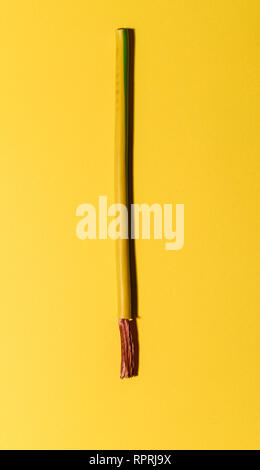 Câble électrique sur fond jaune. Répartir les fils de cuivre. Fond électrique minimaliste. Banque D'Images