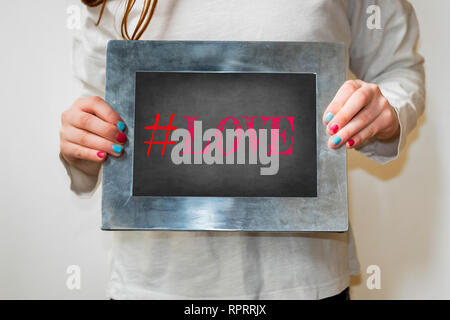 Young Girl holding up blackboard with text # BFF Banque D'Images