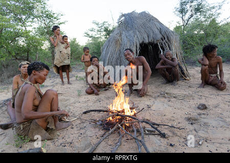 Les San Bushmen de chanter et danser des danses traditionnelles autour du feu en face de la hutte, Kalahari, Namibie, Afrique du Sud Banque D'Images