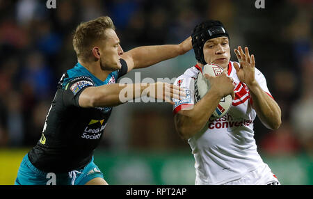 St Helens Saints' Jonny Lomax est abordé par Leeds Rhinos Brad Dwyer, au cours de la Super League Betfred match au stade totalement méchants, St Helens. Banque D'Images