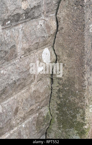 Mur fissuré. Métaphore petit écart, fermer l'écart, la dégradation des infrastructures, ligne de faille. Banque D'Images