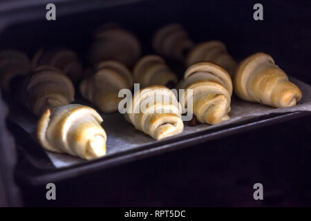 Des croissants frais avec du chocolat sur une plaque de cuisson au four Banque D'Images