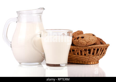 Verseuse et verre de lait avec des biscuits dans un panier en osier isolé sur fond blanc Banque D'Images