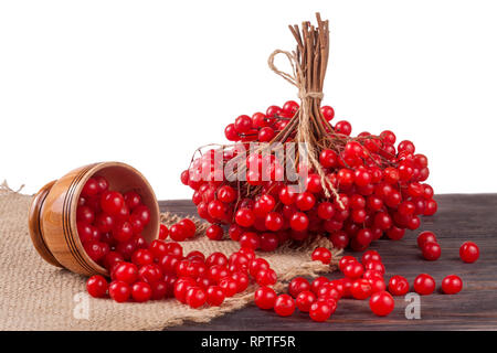 Dans petits fruits rouges mûrs viburnum un bol en bois sur la table isolé sur fond blanc Banque D'Images