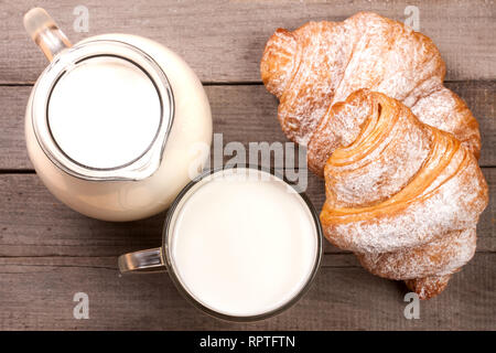 Verseuse et verre de lait avec les croissants sur un fond de bois. Vue d'en haut Banque D'Images