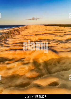 Bien allumé dunes de sable sur Stockton Beach de l'Australie en panorama aérien vertical de haut en bas Vue de surface du terrain jusqu'à distaint horizon et Newcastle. Banque D'Images