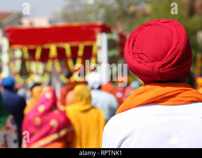 Homme Sikh avec turban rouge et blanc shirt lors de rite religieux en plein air Banque D'Images
