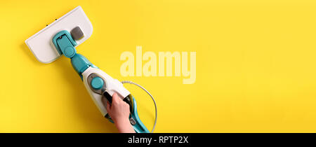 Nettoyeur vapeur mop sur fond jaune. Haut de la vue, télévision lay. Bannière avec copie espace. Le concept de service de nettoyage. Banque D'Images