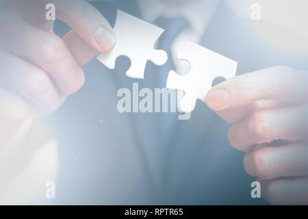 Solutions d'affaires. business man détient deux pièces de puzzle ensemble Banque D'Images