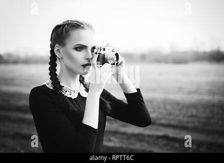 Belle jeune fille tir par le vieux classique caméra. Portrait en extérieur, en noir et blanc Banque D'Images