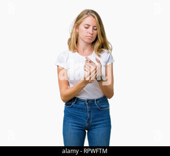 Belle jeune femme portant un t-shirt blanc sur fond isolés souffrant de douleur sur les mains et les doigts, l'inflammation de l'arthrite Banque D'Images