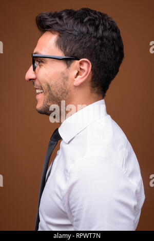 Beau jeune homme d'origine hispanique contre fond brun Banque D'Images