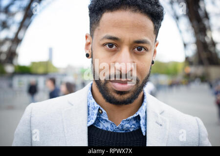 Portrait de jeune homme sérieux, à la mode d'origine africaine sous la Tour Eiffel à Paris, France. Banque D'Images