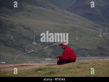 Shanghai, Chine - 18 août, 2016. Un moine tibétain assis sur la colline et à la GAR dans Yarchen au Sichuan, en Chine. Banque D'Images