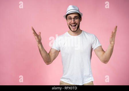 Surpris, l'homme heureux expressif isolé sur rose. Banque D'Images