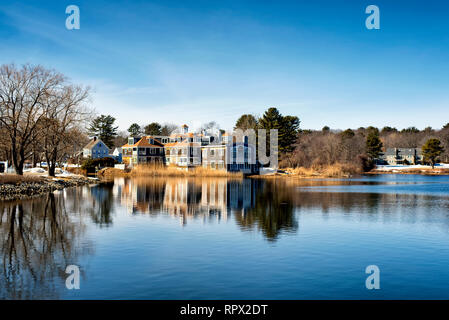 Un grand hôtel qui se reflète sur les eaux de la rivière Batson à Kennebunkport dans le Maine par une froide journée d'hiver ensoleillée. Banque D'Images