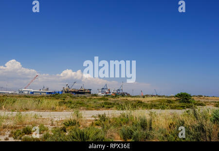 Limassol, Chypre - Juin. 23, 2018 : Avis de Limassol docks prises à partir de l'herbe sauvage terre de Lady's Mile. Pris sur un ciel bleu d'été après ... Banque D'Images