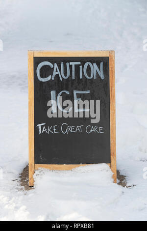 Attention ICE signe sur un chemin dans la neige de l'hiver. Avebury, dans le Wiltshire, Angleterre Banque D'Images