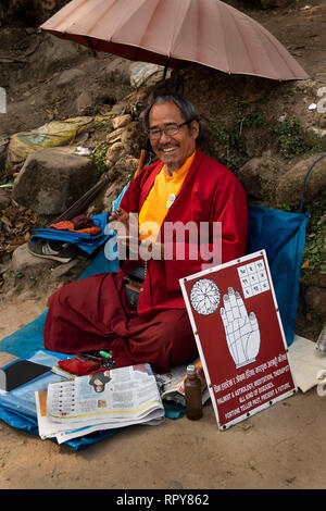 Le Népal, Katmandou, Temple de Swayambhunath, Bhoutanais, le moine bouddhiste offrant la lecture de palm sur mesures pour temple Banque D'Images