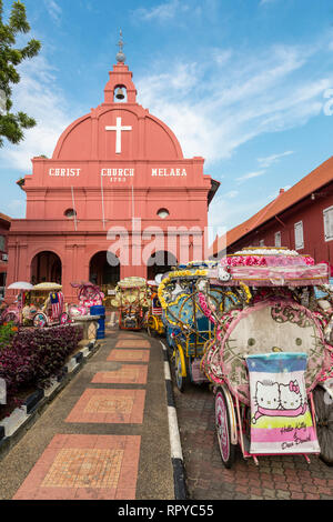 Trishaws vous attendent les touristes en face de Christ Church, construit 1753, Melaka, Malaisie. Banque D'Images