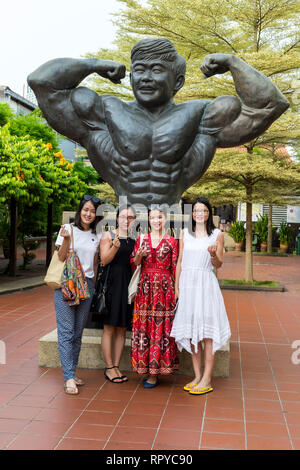 Boon Gan Leong Statue, père de culturisme de Malaisie, les femmes chinoises et les touristes, Melaka, Malaisie. Banque D'Images