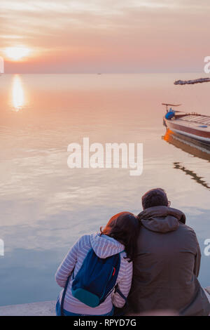 Valencia, Espagne - Février 23, 2019 : l'épaule de son ami tout en regardant le coucher du soleil. Couple d'amoureux au bord du lac. Banque D'Images