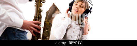 Belle fille à profiter de la musique écoute au casque sax tune man and woman studio shot over white background panoramique copyscape pour votre texte Banque D'Images