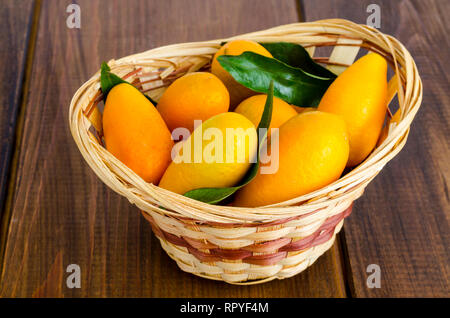 Le kumquat fortunella mûrs sweet orange dans le panier en bois. Studio Photo Banque D'Images