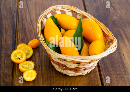 Le kumquat fortunella mûrs sweet orange dans le panier en bois. Studio Photo Banque D'Images