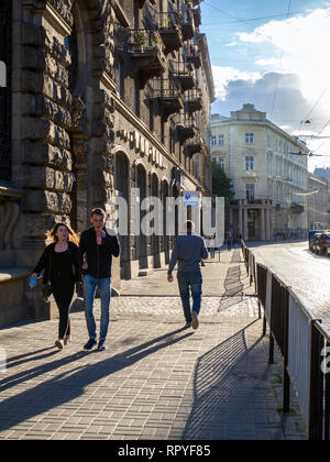 Les piétons circulant dans une rue de la vieille ville de Lviv, en Ukraine. Son architecture bien préservée, qui mélange les styles d'Europe centrale et orientale Banque D'Images