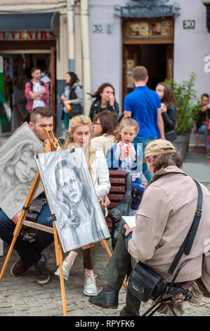 Une peinture de l'artiste portraits de touristes dans la place du marché de Lviv, Ukraine occidentale. Banque D'Images