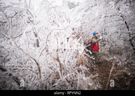 (190223) -- Wuhan, 23 février 2019 (Xinhua) -- Fei Wan, 40, le chef de l'équipe d'inspection de la compagnie d'alimentation Wuhan sous State Grid Corporation, promenades à travers une route boueuse dans la zone de montagne de Wuhan, capitale de la province du Hubei en Chine centrale, le 12 février 2019. Une équipe d'électriciens a été envoyé pour réparer un fil haute tension qui a été rompu en raison de l'épaisse couche de l'accumulation de glace. Après une journée de travail sur le plus de 40 mètres de haut de la tour de transmission de puissance de mauvaise condition météorologique, l'équipe réussi à fixer la défaillance de l'alimentation système qui réduit la vitesse des trains de retarder pendant Banque D'Images