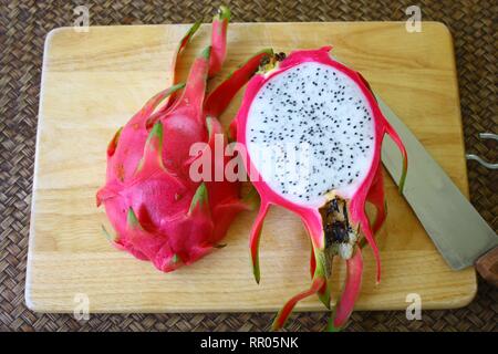 Fruit du dragon rouge avec demi tranche sur la carte d'achats à l'aide d'un couteau Banque D'Images