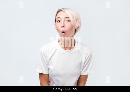 Oh mon Dieu concept. Funny femme européenne avec les cheveux teints et les taches de rousseur et largement la bouche d'ouverture yeux popping out, surpris, choqué avec quelques unexpecte Banque D'Images