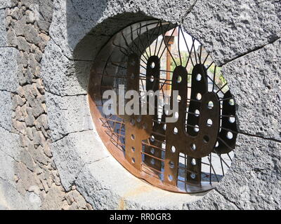 Un ovale couper dans le mur, avec des formes de cactus métal fournit la première vue dans le jardin de cactus conçu par l'artiste de Lanzarote, César Manrique. Banque D'Images