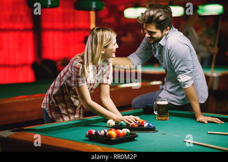 Jeune couple jouant ensemble en snooker pub Banque D'Images