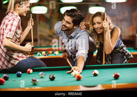 Jeu de billard. jeunes amis jouant au billard ensemble Banque D'Images