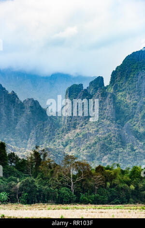 Vue magnifique d'une des montagnes de calcaire éclairée par quelques rayons de soleil qui filtre à travers quelques nuages. Vang Vieng, Laos. Banque D'Images